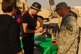 Private 1st Class Benjamin Whittaker, a Boise, Idaho, native and an infantryman with1st Battalion, 8th Cavalry Regiment, 2nd Brigade Combat Team, 1st Cavalry Division, gets singer Kid Rock's signature during a visit to Joint Security Station McHenry in Kirkuk province, Iraq, Dec. 2. Rock, accompanied by comedian Carlos Mencia and singer Jessie James, visited McHenry prior to performing at Forward Operating Base Warrior also in Kirkuk province, as part of an U.S, Air Force Reserve sponsored tour dubbed 'Tour for the Troops 2009'.