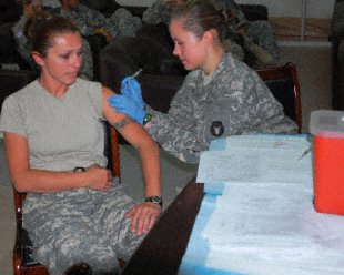 Spc. Albana Luli, a transport management specialist with the 159th Support Operations Company, receives her H1N1 shot from Pfc. Amber Hale, a medic with the 34th Infantry Division in the one of the Morale, Welfare and Recreation buildings on Contingency Operating Base Basra. Sgt. Francis Horton