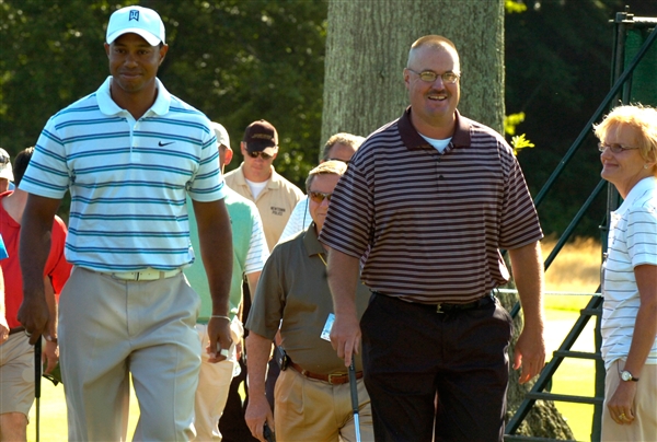 Golfers Tiger Woods and Air Force Chief Master Sgt. George Vasiloff of the Pennsylvania Air National Guard walk up to their approach shot as fans cheer in admiration for both at the AT&T National Pro-AM at Aronomink Country Club in Newtown Square, Pa., June 30, 2010. Vasiloff was selected to play with Woods just weeks after returning from combat in Afghanistan. U.S. Air Force photo by Capt. Jay Ostrich  