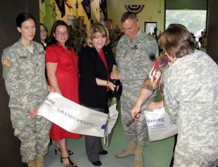 Army Lt. Gen. Jack C. Stultz and his wife, Laura, center, cut the ribbon at the official grand opening of the first Army Strong Community Center in the Wadsworth Army Reserve Center in Rochester, N.Y., Sept. 12. Michelle Zelaya, to their left, is one of the two full-time staffers and many volunteers credited with providing assistance to families whose loved ones are deployed, but don't live close enough to a major installation to tap into its services.  Donna Miles